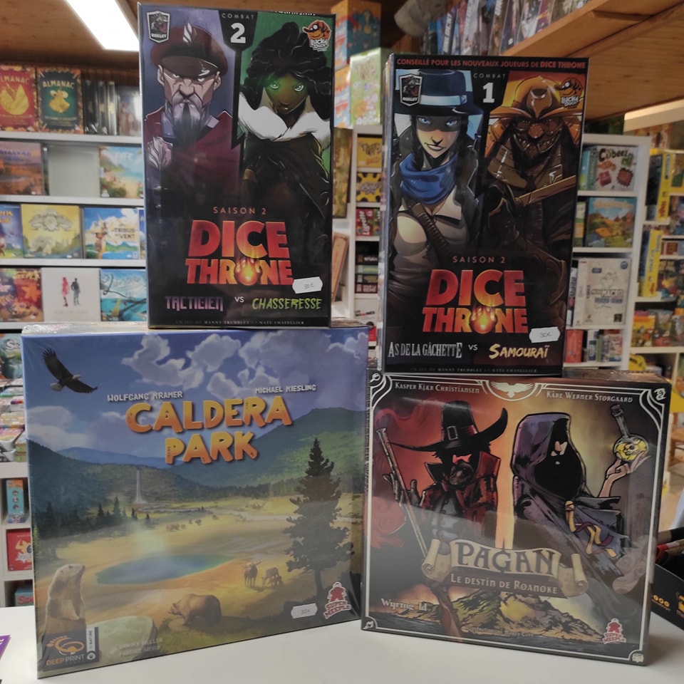 Photo des boîtes des jeux "Dice Throne : Tacticien vs Chasseresse", "Dice Throne : As de la gâchette vs Samouraï", "Caldera Park" et "Pagan : Le Destin de Roanoke"